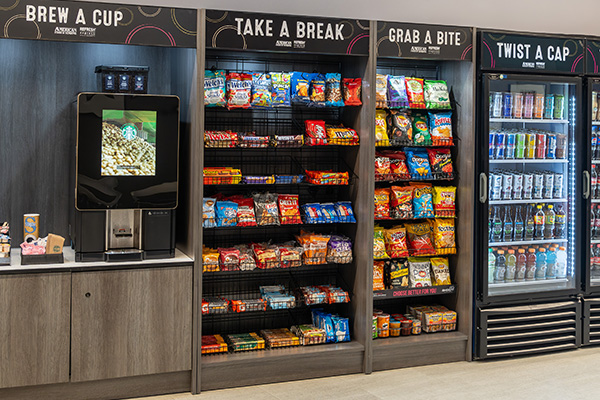 Wall-mounted micro market with coffee station, snack shelving, and beverage cooler zones